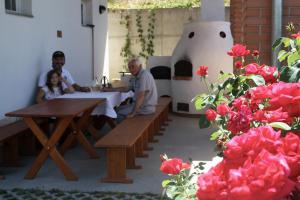 un grupo de personas sentadas en una mesa en un restaurante en Galambos Pincészet, en Abaújszántó