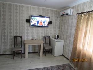 sala de estar con mesa y TV en la pared en Salus en Khmelʼnytsʼkyy