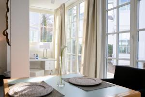 a living room with a table and some windows at Atelier-Appartement Ambienta im Zentrum von Binz in Binz