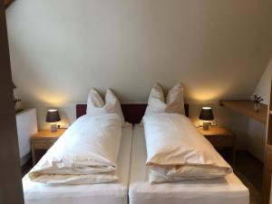 1 Schlafzimmer mit 2 Betten und weißen Kissen in der Unterkunft Gasthof zum Ochsen in Mössingen