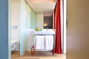 a bathroom with a white sink and a red shower curtain at The Editory House Ribeira Porto Hotel in Porto