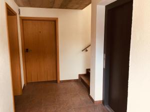 einen leeren Flur mit Holztür und Treppe in der Unterkunft Gasthof zum Ochsen in Mössingen
