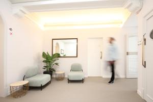 un hombre caminando a través de una habitación con sillas y un espejo en Regina Selfcheck-in Smart Rooms, en Palma de Mallorca