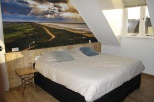 1 dormitorio con 1 cama con una pintura en la pared en Hiltop, en Domburg