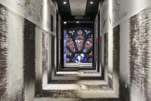 un corridoio con vetrata colorata in una chiesa di Martin's Dream Hotel a Mons