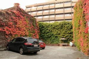 デュッセルドルフにあるホテル ムーンの建物前の駐車場に駐車した車2台