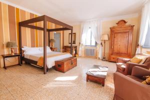 a bedroom with a canopy bed and a couch at Villa La Bianca in Camaiore