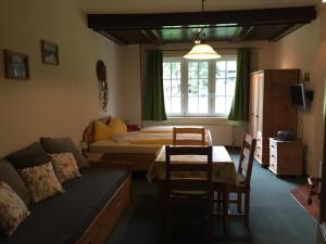 una sala de estar con un sofá y una cama en Landhaus Gohrisch, en Kurort Gohrisch