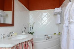a white bathroom with a tub and a sink at Hotel Splendid in Cannes