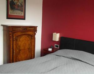 a bedroom with a bed and a red wall at Schuster Villa in Markneukirchen
