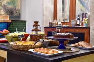 a buffet with bread and other food on a table at The Editory House Ribeira Porto Hotel in Porto