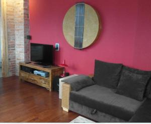 uma sala de estar com um sofá e uma televisão de ecrã plano em Schuster Villa em Markneukirchen