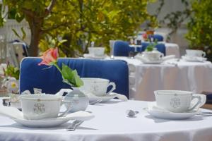 a table with white tea cups and saucers on it at Hotel Splendid in Cannes