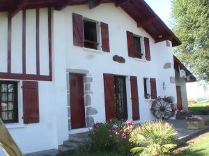 a white house with red doors and windows at Appartement au coeur du pays basque : vue superbe in Saint-Esteben
