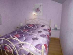 a bedroom with a bed with a purple comforter at Appartement au coeur du pays basque : vue superbe in Saint-Esteben