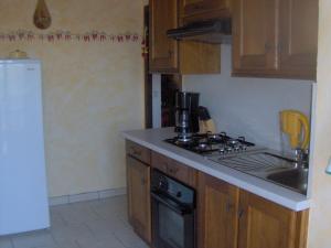 a kitchen with wooden cabinets and a stove top oven at Appartement au coeur du pays basque : vue superbe in Saint-Esteben