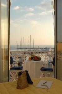 een tafel op een balkon met uitzicht op een jachthaven bij Hotel Splendid in Cannes