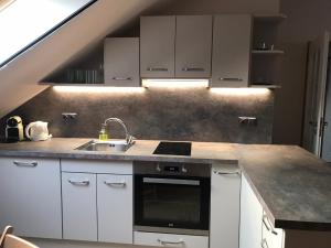 a kitchen with white cabinets and a sink at Apartmany U Stareho Labe in Nymburk