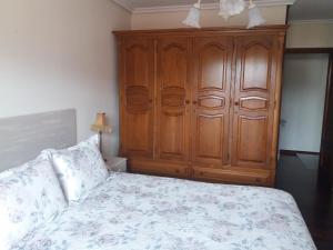 - une chambre avec une armoire en bois et un lit dans l'établissement Saron Centro, à Sarón
