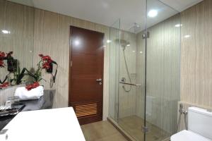 um banheiro com chuveiro e porta de vidro em Hotel Permata Bogor em Bogor