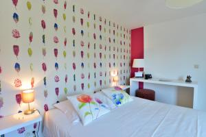 a bedroom with a bed and a wall with flowers at Hotel Durbuy Ô in Durbuy