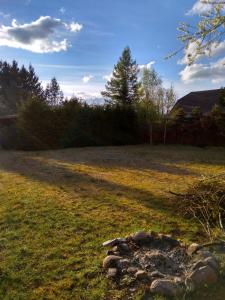 a field with a fire pit in the grass at Tomaszówka in Płaska