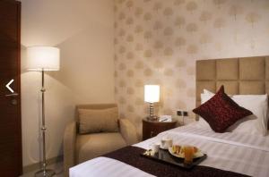 um quarto de hotel com uma cama com uma bandeja de comida em cima em Hotel Permata Bogor em Bogor