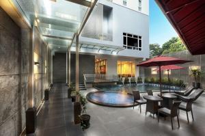 un edificio con piscina con tavoli e sedie di Hotel Permata Bogor a Bogor