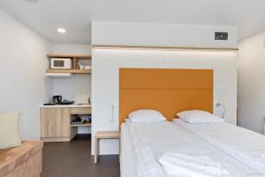 1 dormitorio con 1 cama grande y cabecero en First Camp Skönstavik Karlskrona en Karlskrona