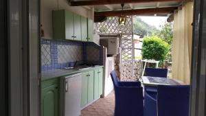 una cucina con armadi verdi e un tavolo con sedie di Villa La Gioiosa a Maratea