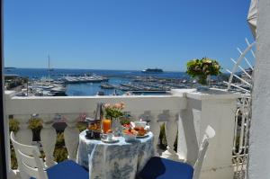 a table on a balcony with a view of a harbor at Hotel Splendid in Cannes