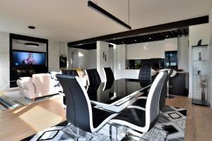 Villa A في سراييفو: غرفة معيشة مع كراسي سوداء وبيضاء وتلفزيون