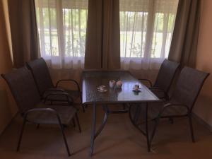 a dining room table with four chairs and a table with candles on it at Sziksósfürdő Strand és Kemping in Szeged