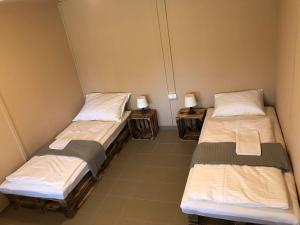 2 Betten in einem Zimmer mit 2 Lampen an Tischen in der Unterkunft Sziksósfürdő Strand és Kemping in Szeged
