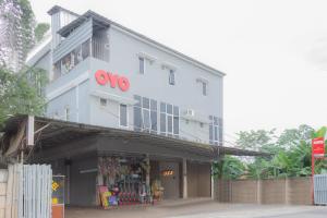 a white building with a red oo sign on it at OYO 39077 Guesthouse in Tjilandak