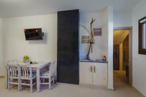 a dining room with a table and a tv on a wall at Marilias Apartment in Kamari