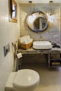 a bathroom with a sink and a toilet and a mirror at Marilias Apartment in Kamari +25 photos