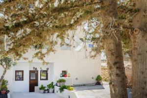 a white building with trees in front of it at Marilias Apartment in Kamari