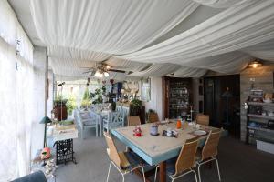 une salle à manger avec une table et des chaises sous une tente dans l'établissement IL NIDO AL LAGO, à Gavirate