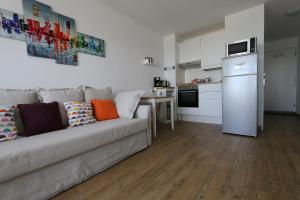 sala de estar con sofá y cocina en Hendaye Beach Studio, front de mer avec parking privé, en Hendaya