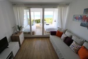 ein Wohnzimmer mit einem Sofa und Blick auf ein Schlafzimmer in der Unterkunft Hendaye Beach Studio, front de mer avec parking privé in Hendaye