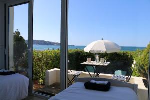 1 dormitorio con vistas al océano y mesa con sombrilla en Hendaye Beach Studio, front de mer avec parking privé, en Hendaya