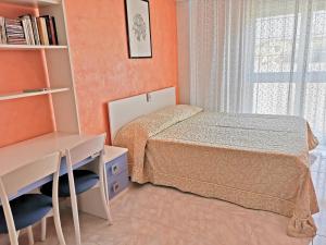 1 dormitorio con cama, escritorio y ventana en Capitan Shonny, en Portoscuso