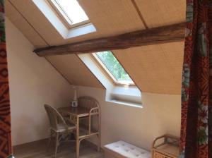 an attic room with a table and skylights at L’Orme des voyageurs in Boutigny