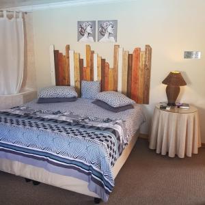 a bedroom with a bed and a table with a lamp at Jolani 2 Guest House in Welkom +50 photos