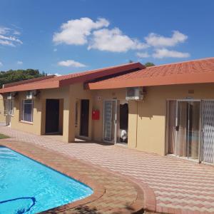 a house with a swimming pool in front of it at Jolani 2 Guest House in Welkom