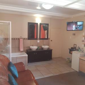 a bathroom with two sinks and a bath tub at Jolani 2 Guest House in Welkom