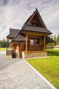 a log cabin with a walkway in front of it at Morcinowe Chałpy in Murzasichle