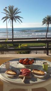 una mesa con un plato de comida en la playa en Apartamento Primera Linea de Mar, Cunit, en Cunit