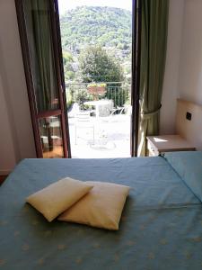 a pillow sitting on a bed in front of a window at Hotel Fioroni in Bellagio